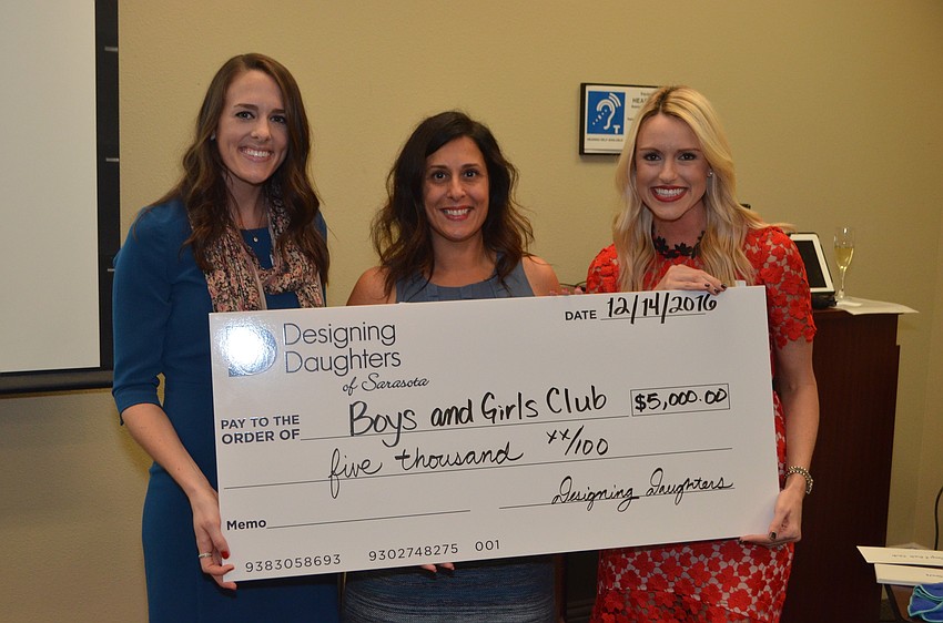 Sara Bealor and Yolanda Mancha of Boys and Girls Clubs of Sarasota County receive a grant check from Montana Taplinger.