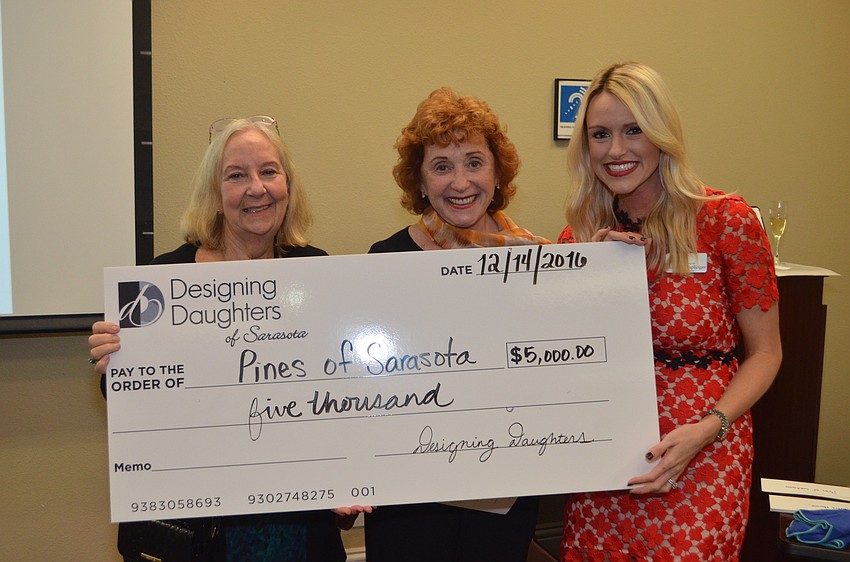 Marlene Simons and Estelle Crawford of Pines of Sarasota receive a grant check from Montana Taplinger.