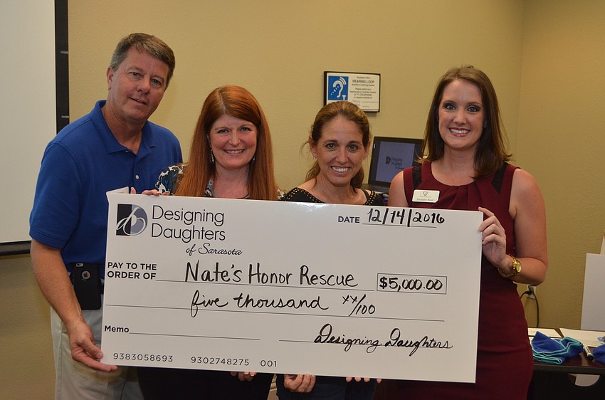Rob Oglesby, Karen Slomba and Dar Oglesby of Nate’s Honor Rescue receive a grant check from Jen Rust.