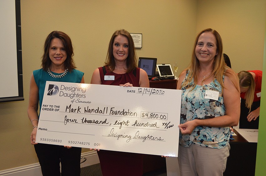 Melissa Wandall, Jen Rust and Wendy Orlando pose with the grant check for the Mark Wandall Foundation.