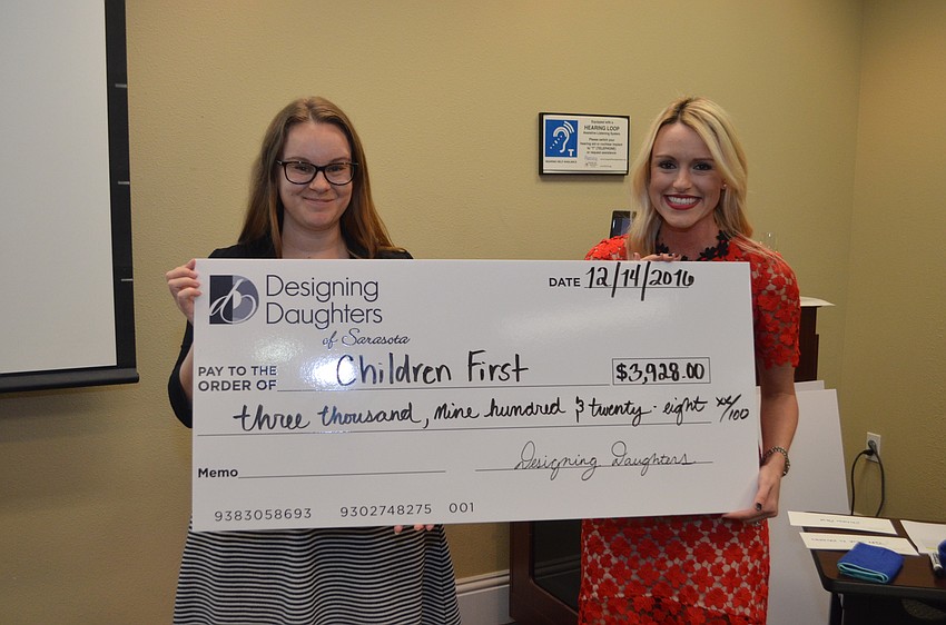 Megan Wenger of Children First receives a grant check from Montana Taplinger.