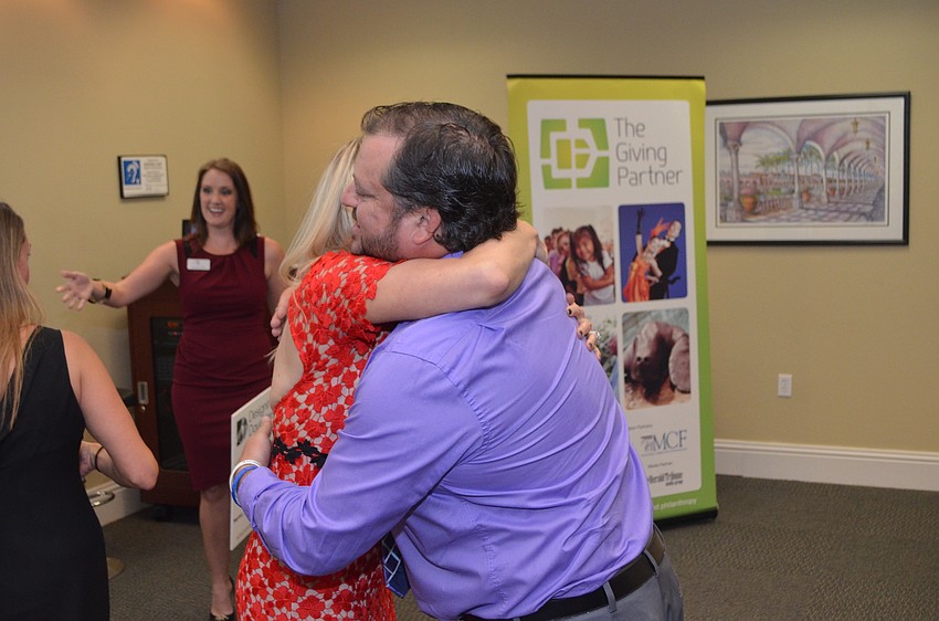 Montana Taplinger hugs Rich Stroud of Everyday Blessings before giving him his grant check.