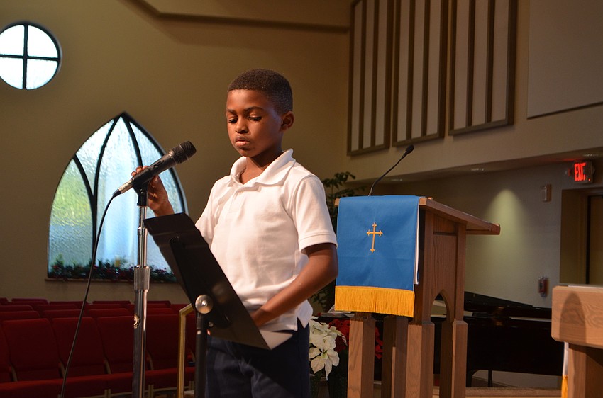 Malik Taylor reads during the service of Christ Church’s Reading Buddies holiday party.