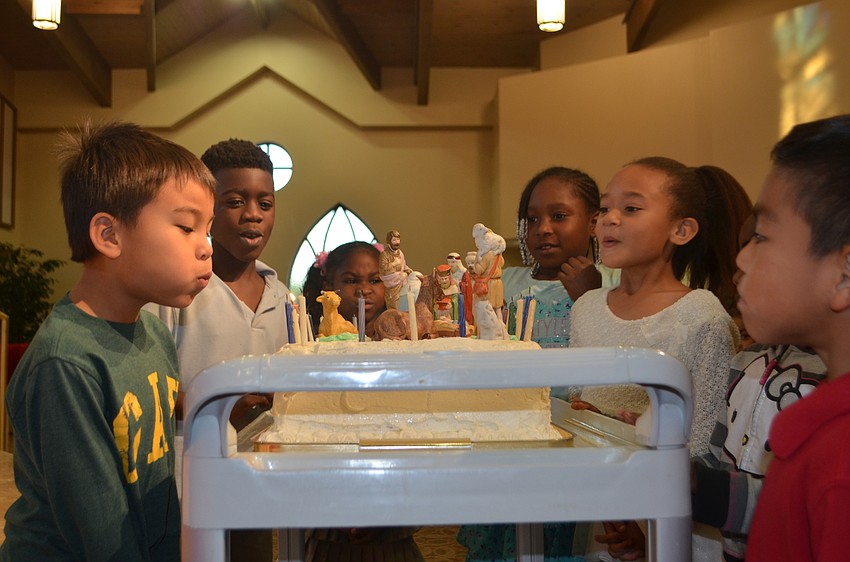 First graders of 13th Avenue Dream Center of Bradenton blow out candles on the birthday cake for Jesus.