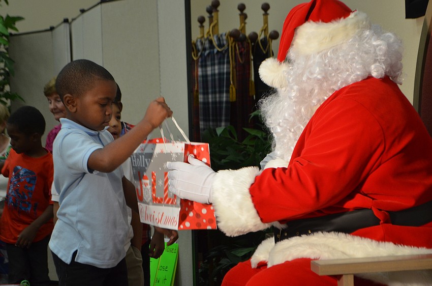 Erik Brooks accepts his gift from Santa Claus during Christ Church’s Reading Buddies holiday party.