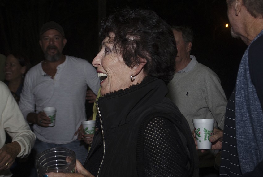 Sandra Johnston greets the judges as they arrive at the Bay Tree Club to view its light display.