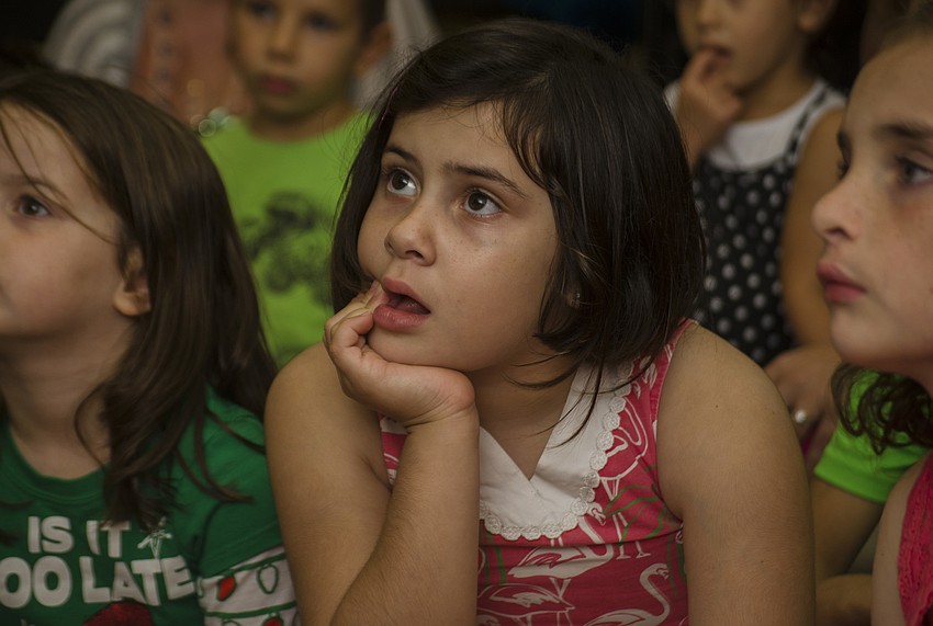 Francesca Varone listens as Laura Freedman reads Hanukkah related books.