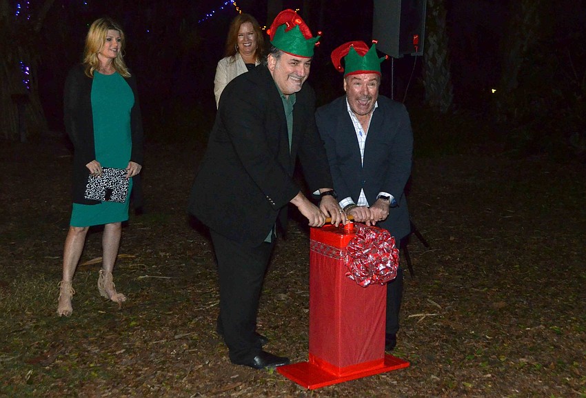 Kim Mancini and Terri Klauber watch their husbands, Phil Mancini and Michael Klauber, react after turning on the Christmas lights at Selby.