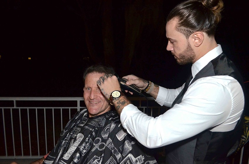 Andre Pergolese of Fresko Fadez Barbershop gives Brent Rubin a haircut.