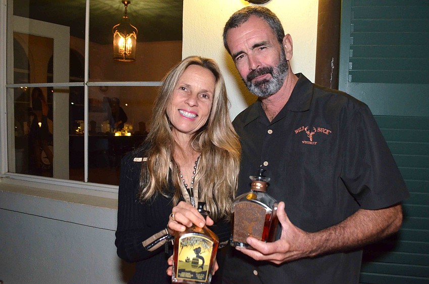 Natalie Joy and Kevin S. Goff of NJoy Spirits Distillery pose with their Mermaid Rum and Wild Buck Whiskey.