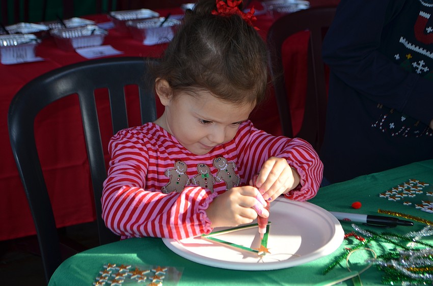 Samantha Carmona, 3, makes a Christmas tree craft.