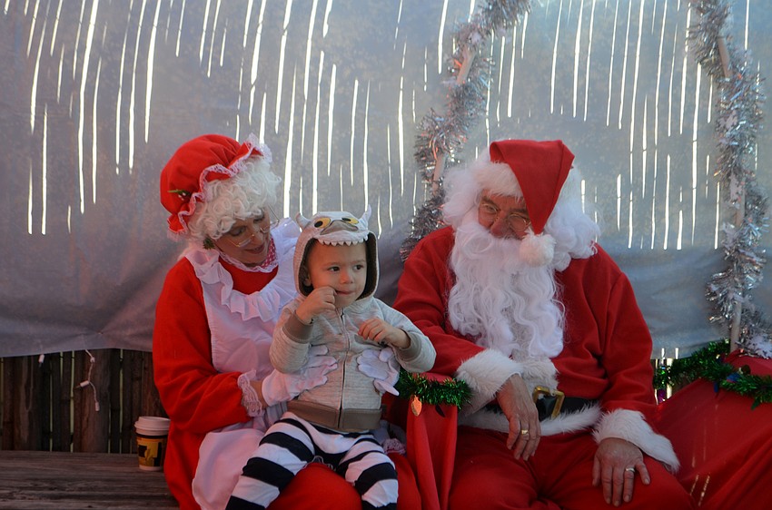 Nathaniel Godschall, 2, seemed to be more interested in the candy cane Mrs. Claus gave him than talking with Santa.