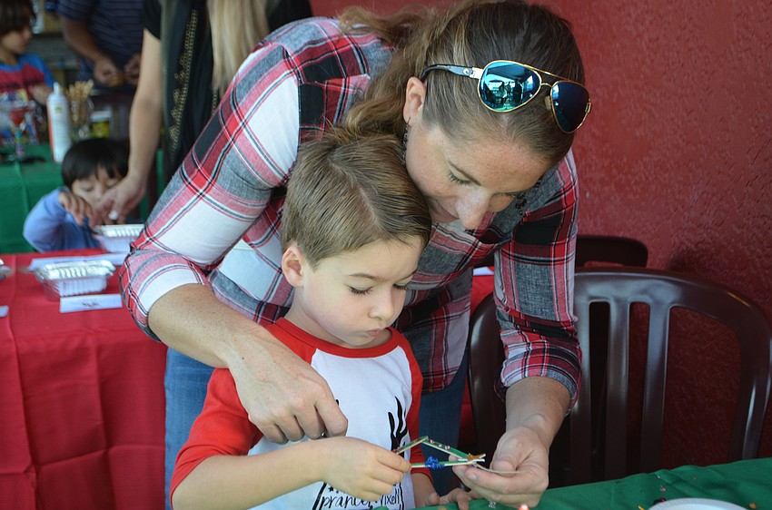 Suzanne and Brandon Parrish, 4, make a Christmas tree craft during breakfast with Santa at The Old Salty Dog on Dec. 17.