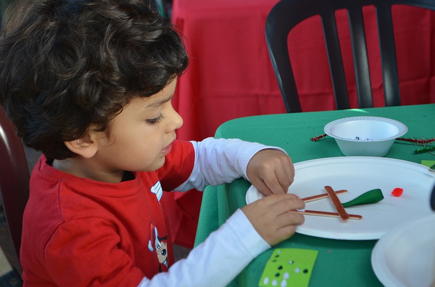 Alejandro Bringas, 3, makes a reindeer craft at The Old Salty Dog on Dec. 17. Santa and Mrs. Claus took a trip down from the North Pole to have breakfast and visit with customers.