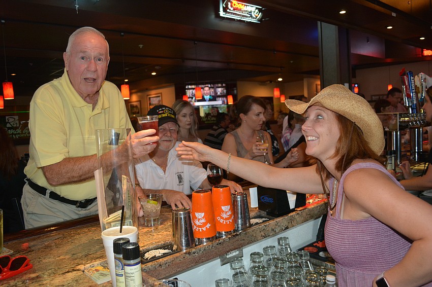 John Carr of Greenbrook takes a drink from Sierra Butler, who was trying out her bartending skills for Cheers for Charity.