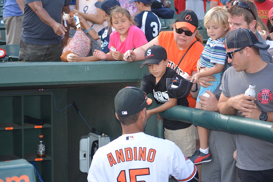 Baltimore Orioles infielder Robert Andino signs autographs for fans.