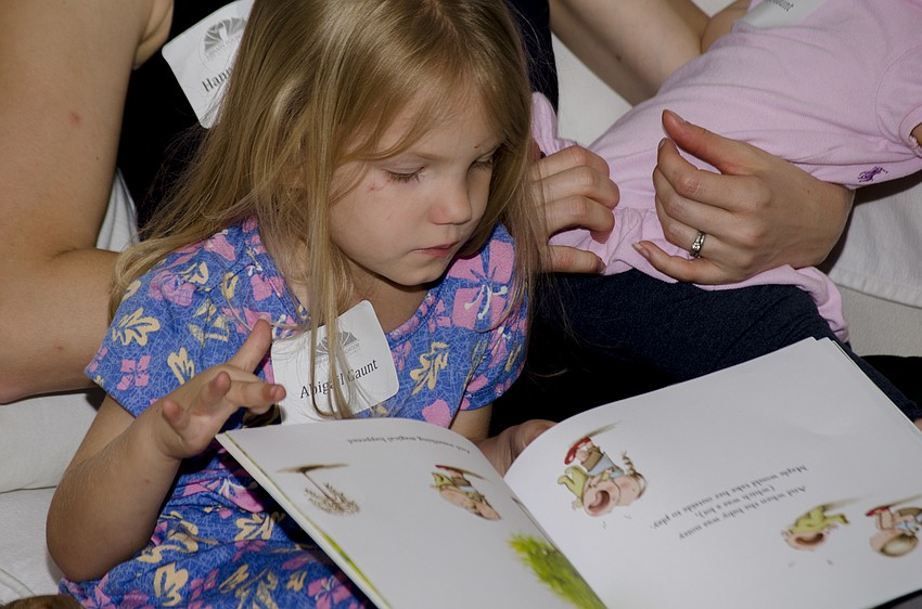 Abigail Gaunt reads while members of the Library Foundation thank their fellow members for their efforts in raising $500,000 for the Children'         s Literacy Endowment.