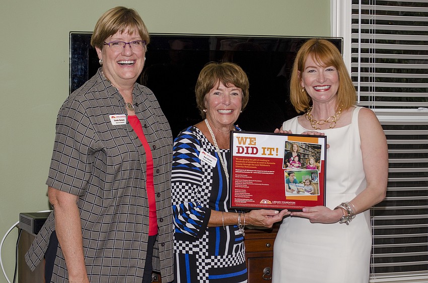 President of the Library Foundation Linda Getzen and Executive Director Suzanne Seiter present Sarasota and Longboat Observer Publisher Emily Walsh with a plague to commemorate the Observer'         s advertising efforts.
