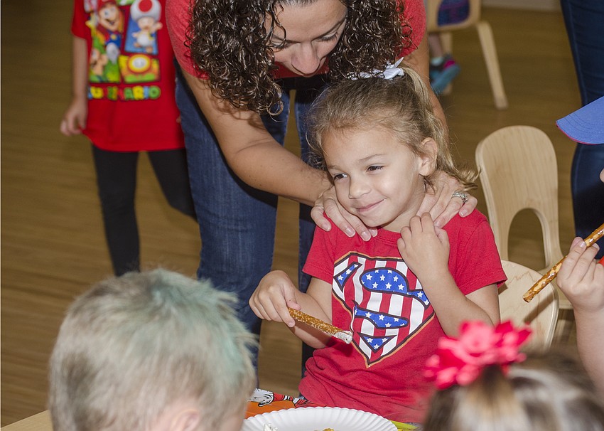 Michelle Marano congratulates her daughter Ari Marano on catching a gold fish with her pretzel and cream cheese fishing rod.