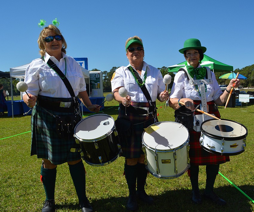 Pam Gates, Linda Yang and Cheri McDonough, members of Lion Rampart Pipe and Drum, get ready to perform.