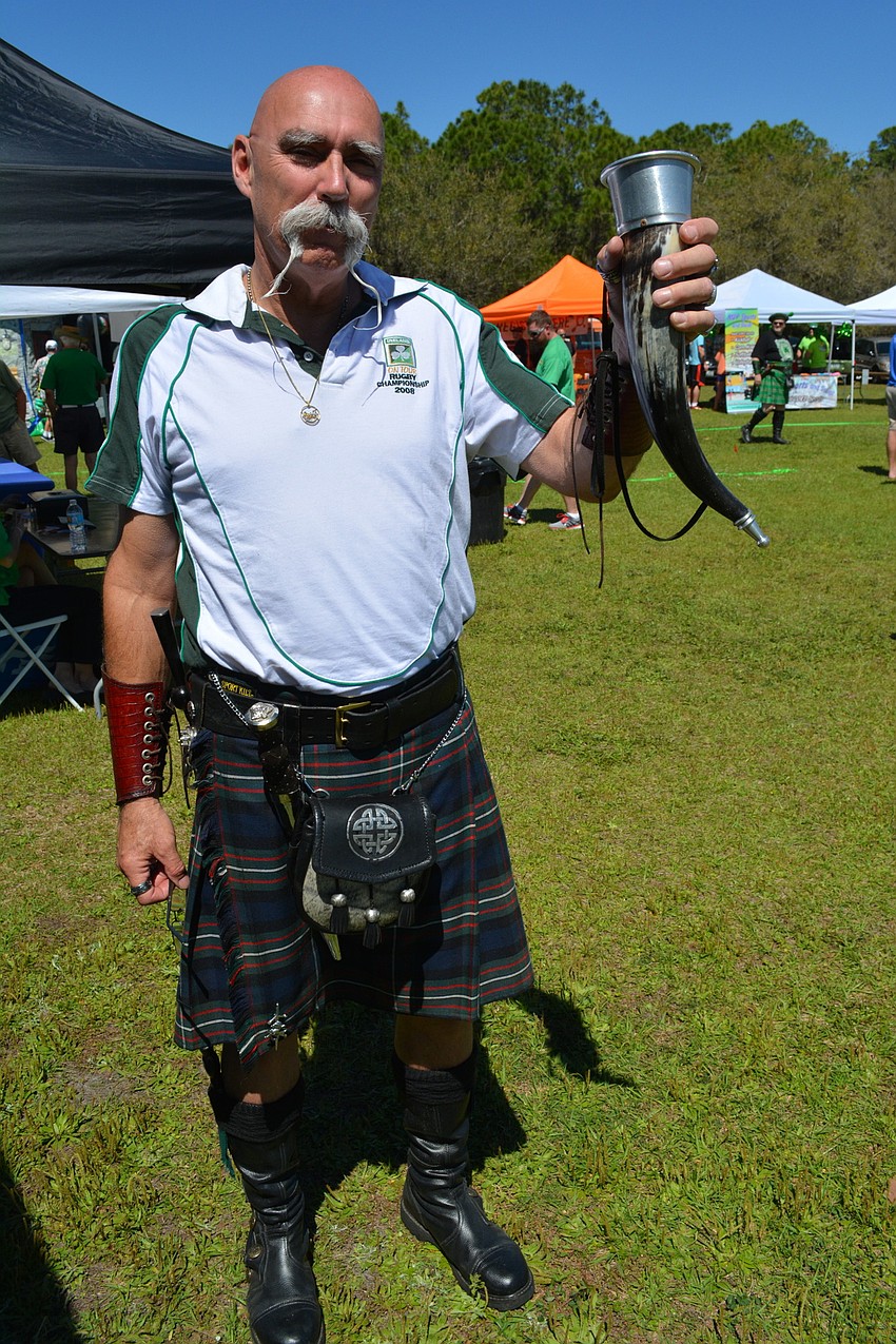 John Gale of Englewood raises a mug and shows off his kilt at the Irish Celtic Festival.