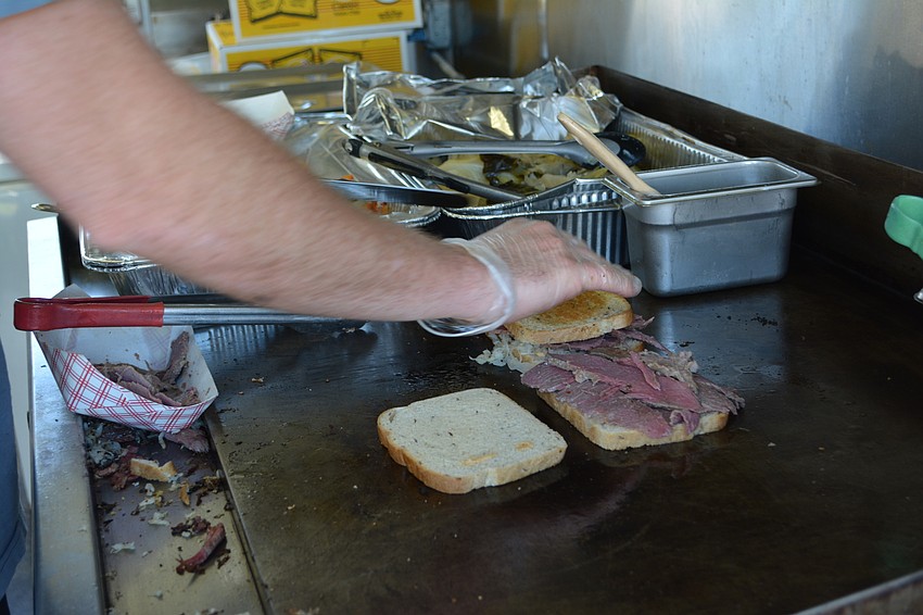 Above the Grain cook Benet Hopper puts the finishing touches on a Reuben sandwich.