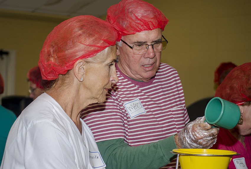 Annarita Scott and Marty Faust assemble meals at St. Boniface Church.
