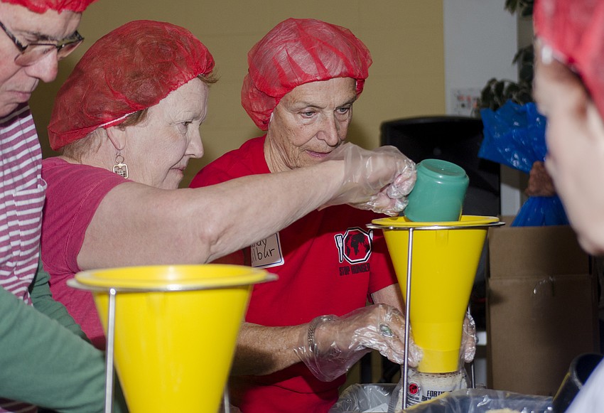 Mary Gordon and Sandy Wilbur assemble meals at St. Boniface Church.