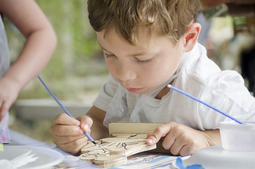 Kaleb DeFuria paints in the craft tent during the festival.