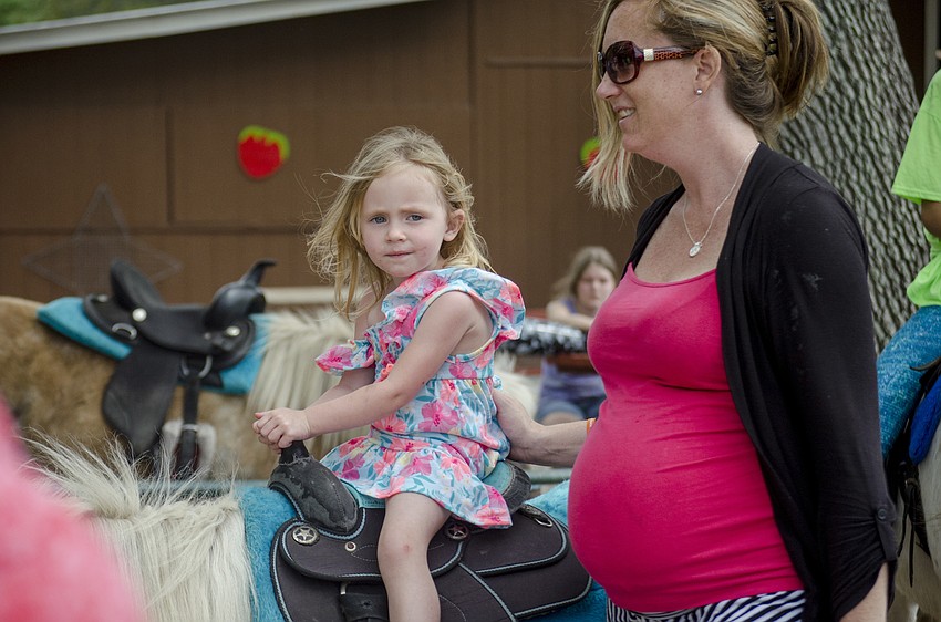 Jenna Jones leads Ava Heonis on the pony ride.
