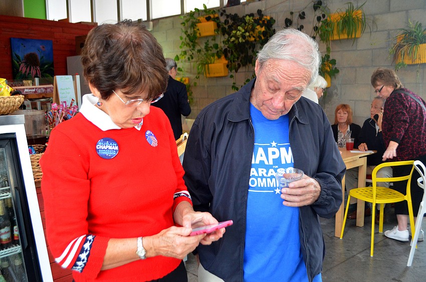 Chapman checks her phone for results. She has been a city commissioner since 2013.