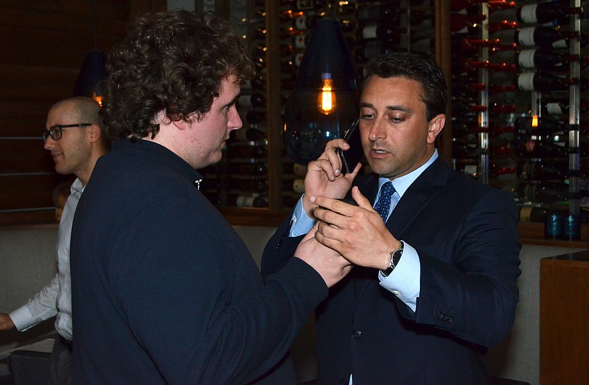 Hagen Brody Campaign Treasurer George Thurlow shows Brody the updated results on his phone.