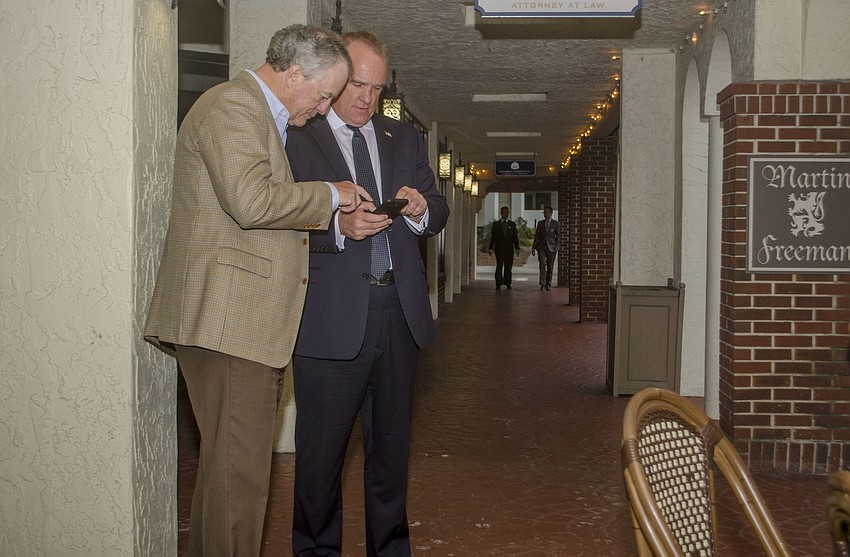 Martin Hyde reviews early polling results with supporters outside his watch party at Caragiulos Italian-American restaurant.