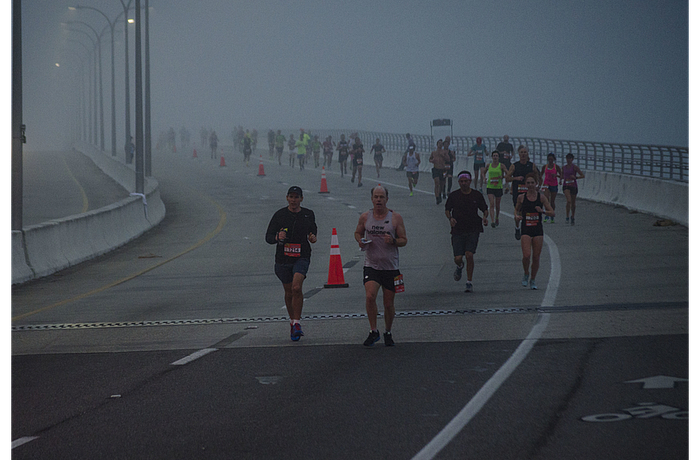 Runners in the Sarasota Music Marathon work their way down the slope of the Ringling Bridge on a foggy February morning.