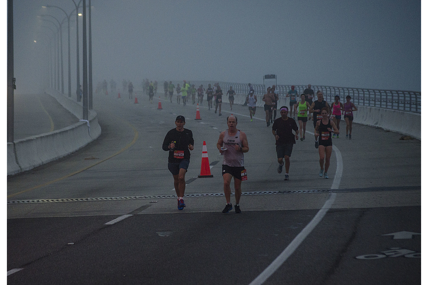 Runners in the Sarasota Music Marathon work their way down the slope of the Ringling Bridge on a foggy February morning.