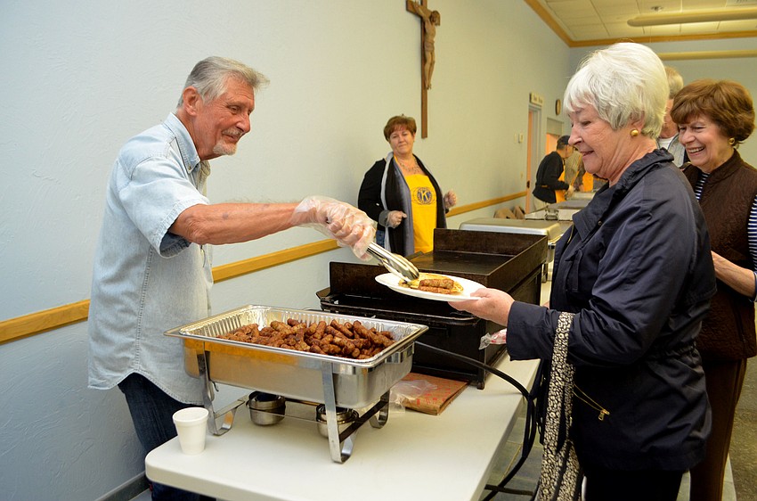 Ed Krepela serves Lisa Peterson sausage links at the Kiwanis Club Annual Pancake Breakfast.