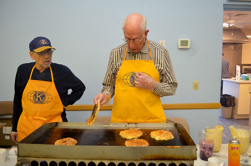 Jim Krenik and Richard March take turns flipping pancakes during the breakfast.