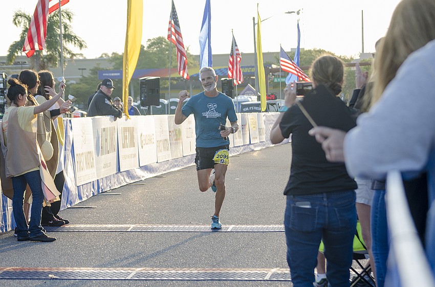 Michael Quigley crosses the finish line of the First Watch Sarasota Half Marathon.