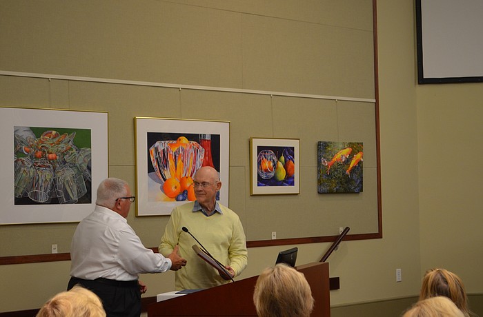Mayor Terry Gans shakes hands with outgoing town commissioner Phill Younger on Monday.
