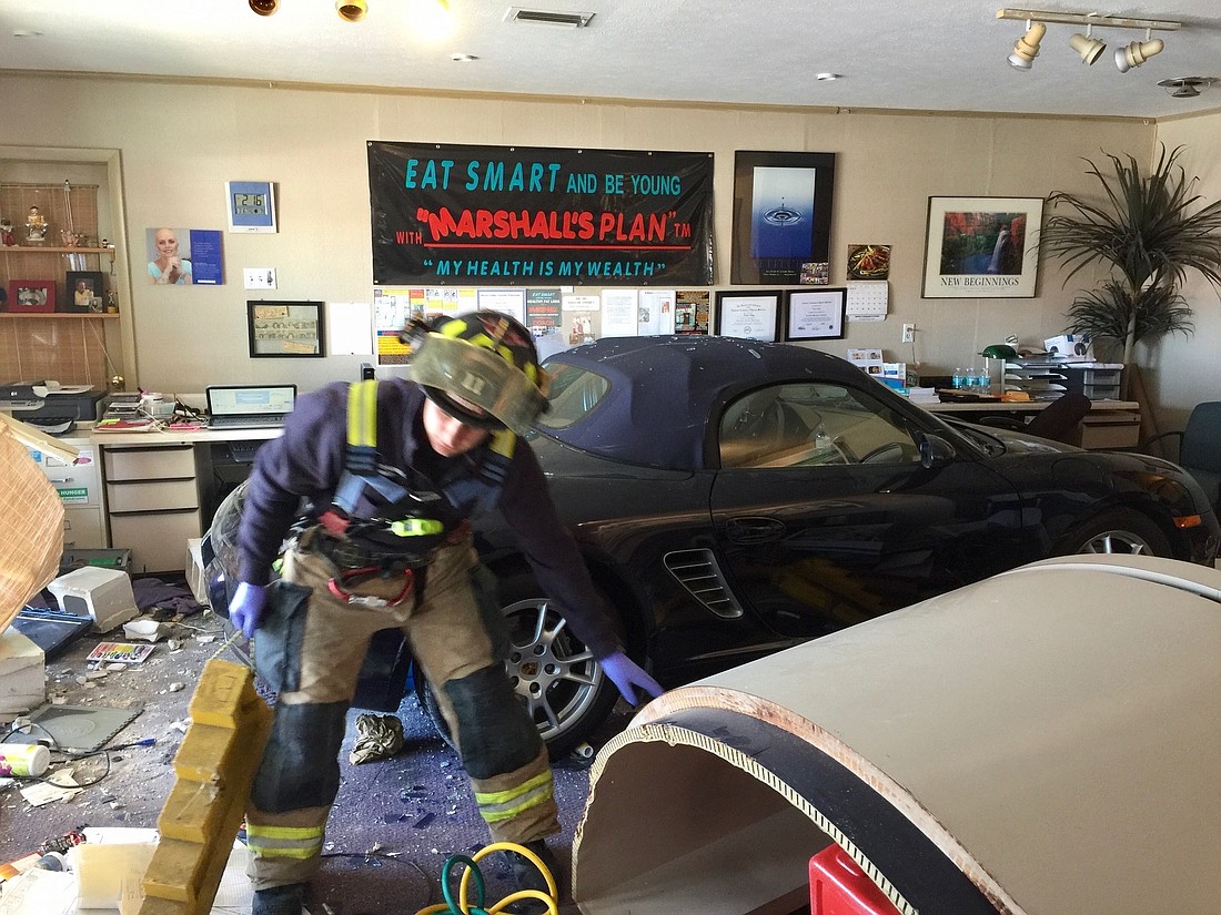 Sarasota County emergency personnel begin picking through the rubble after a car crashed through the front of a south Sarasota business last Thursday.