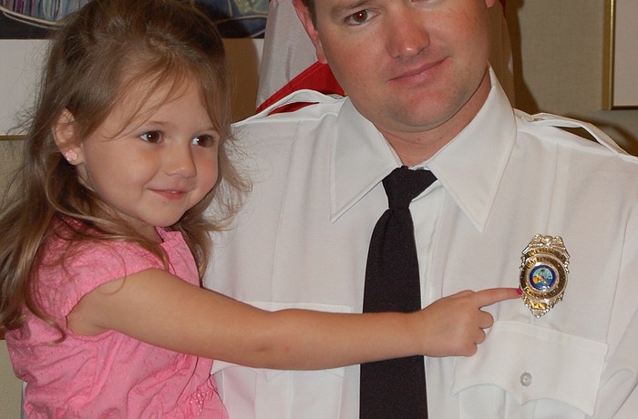 Lydia Franklin admires her father Richard&#39;  s new fire department badge.