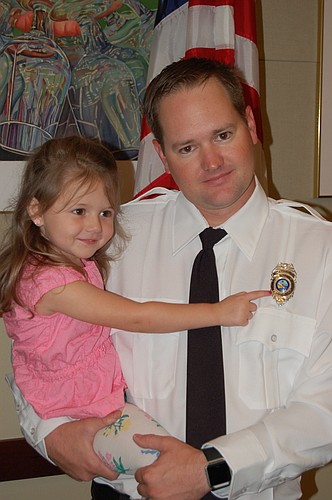 Lydia Franklin admires her father Richard&#39;  s new fire department badge.
