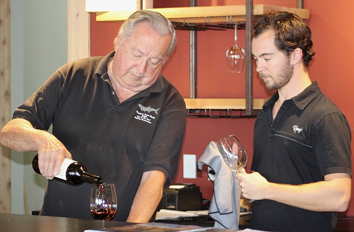 Jim Shortt and his son, Scott Shortt, do a little research on wines they will serve at Fine Wine and Tastings on Main.