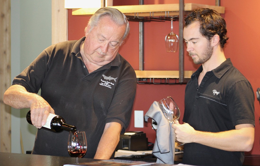 Jim Shortt and his son, Scott Shortt, do a little research on wines they will serve at Fine Wine and Tastings on Main.