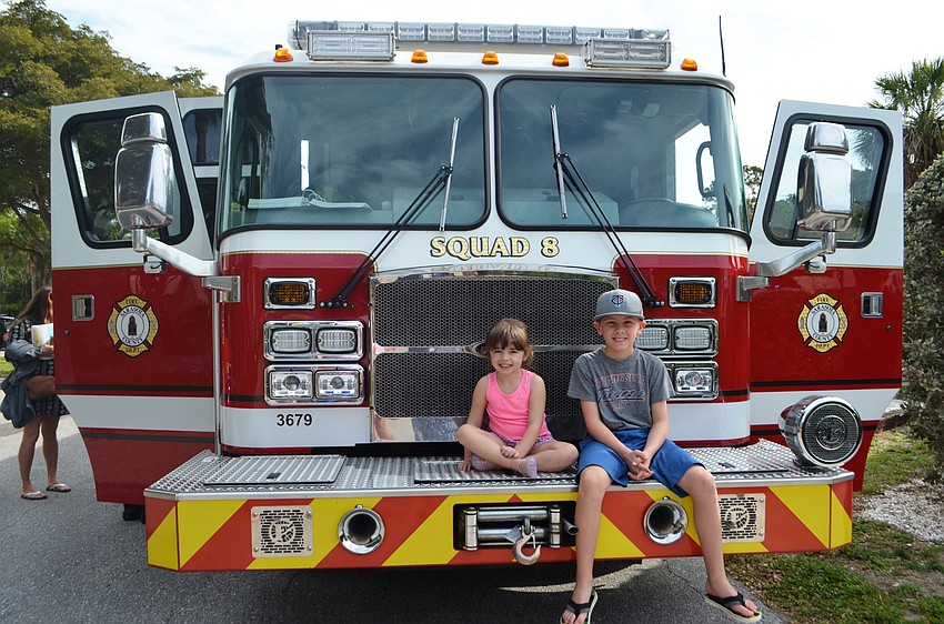 Avery, 4, and Grady Lanz, 8, sit on one of the the firetrucks parked outside Longboat Key’s north fire station during the annual community open house.
