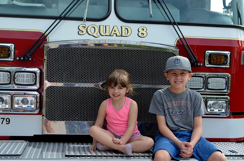 Avery, 4, and Grady Lanz, 8, sit on one of the the firetrucks parked outside Longboat Key’s north fire station during the annual community open house.