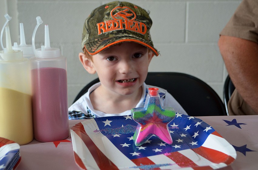Colton Vandermolen, 4, makes sand art in the shape of a star.