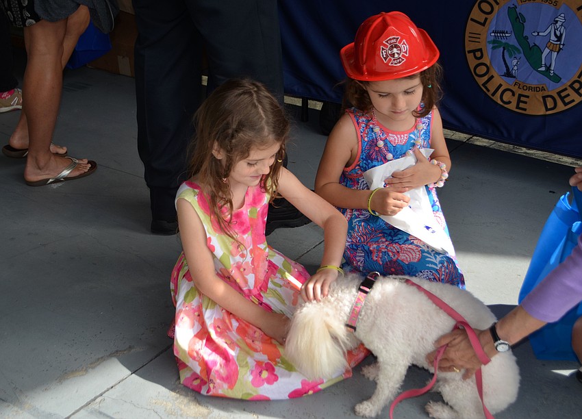 Lexi Gwen and Alahna Smith pet a one of the dogs that was walking around the community open house.