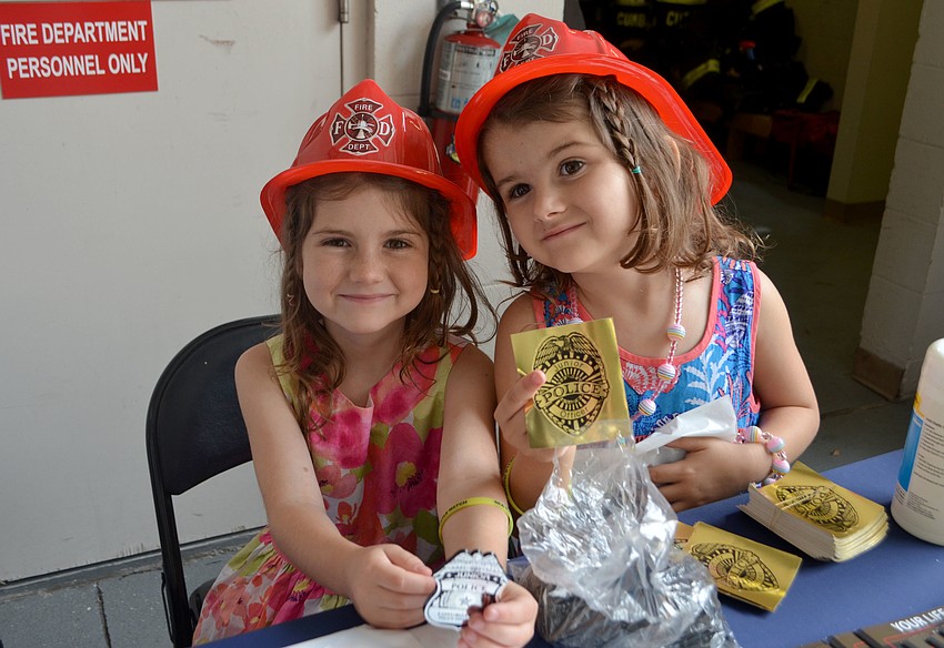 Lexi Gwen and Alahna Smith show of their police badges and stickers.