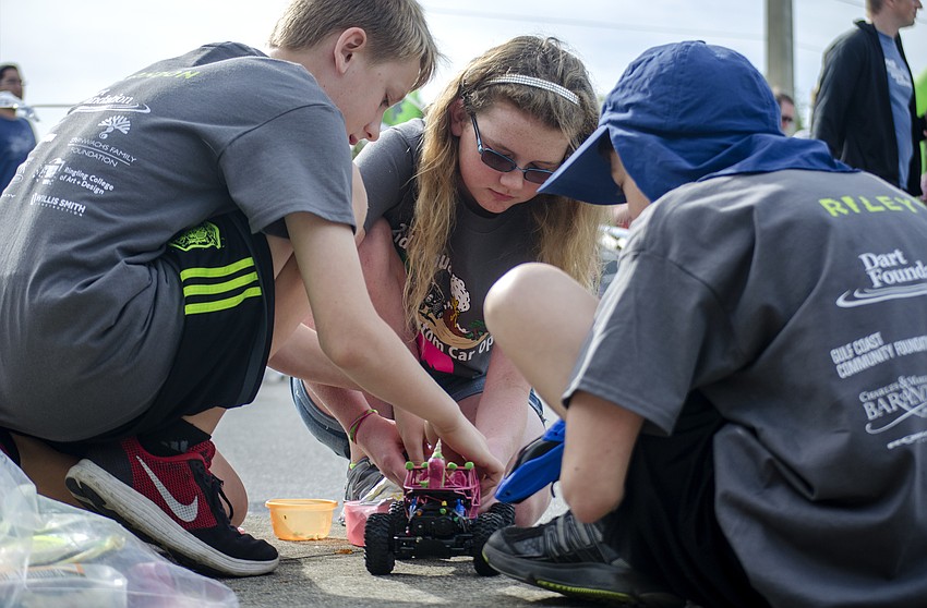 Landon Bertand, Sarah Pflug and Riley Pflug work on some last minute modifications to their remote control car.
